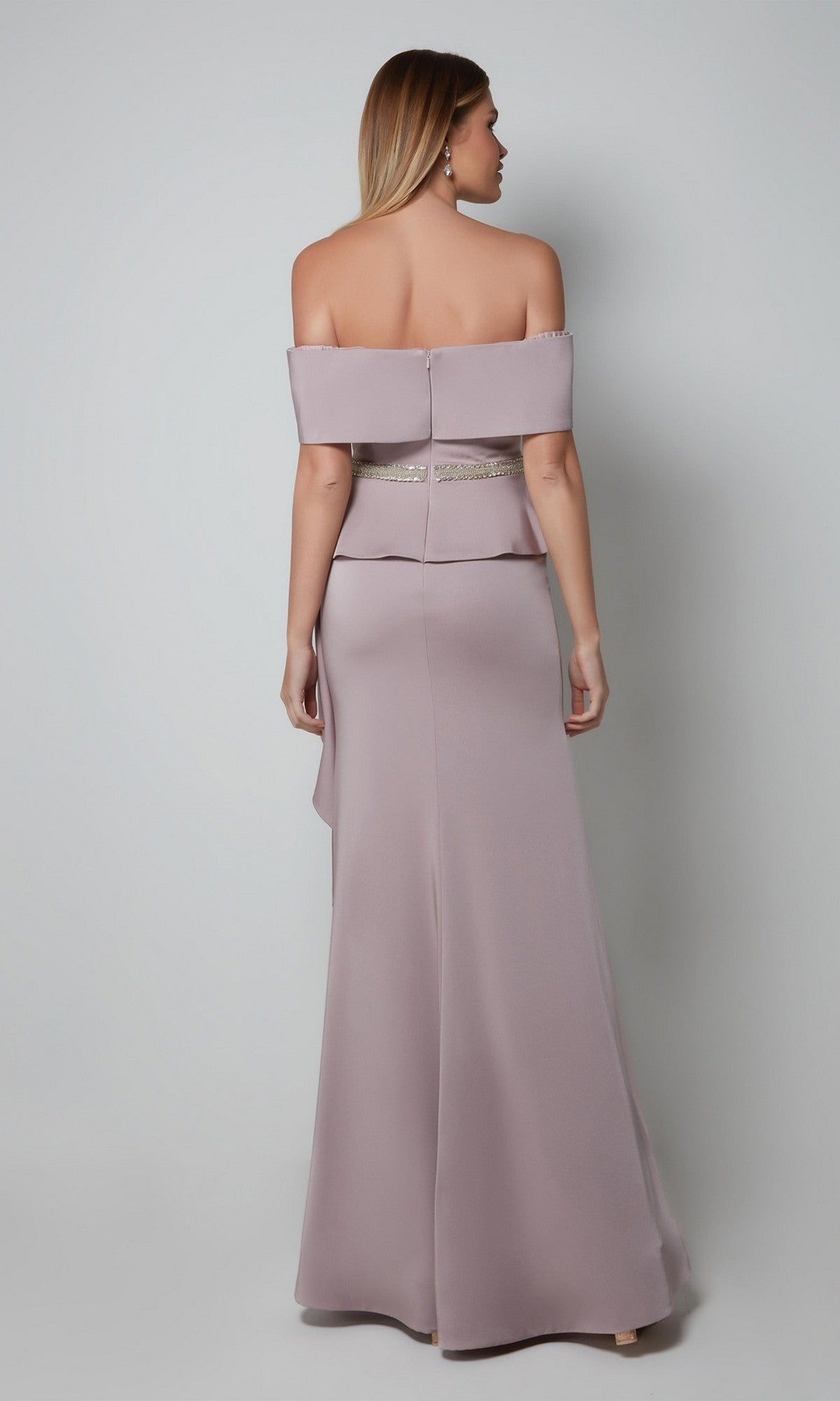 A woman is seen from the back wearing the Alyce 27563, a light mauve, off-the-shoulder, floor-length formal dress with a fitted waist and beaded belt, set against a plain background.