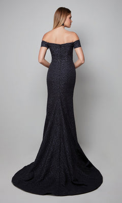 A woman stands with her back to the camera against a plain grey background, wearing the Alyce 27578, a fitted, off-the-shoulder black floor-length formal dress.