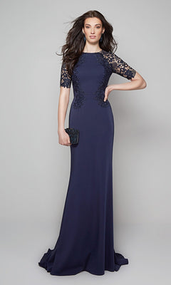 A woman in the Alyce 27585 long formal dress in midnight, featuring a lace bodice and lace-detailed sleeves, holds a black clutch while standing against a plain gray background.