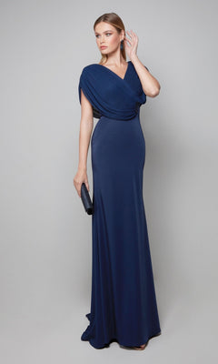 A woman poses against a gray background wearing the Long Formal Dress: Alyce 27591, an elegant navy blue crepe gown perfect as a sophisticated mother-of-the-bride dress, and holds a black clutch purse.