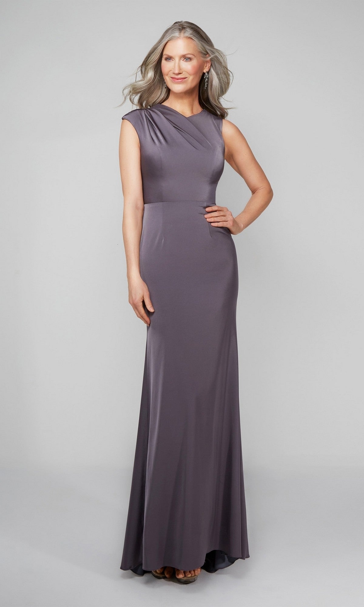 A woman models the Alyce 27598 long formal dress in graphite, a sleeveless, floor-length column gown, posing with one hand on her hip against a plain light background.