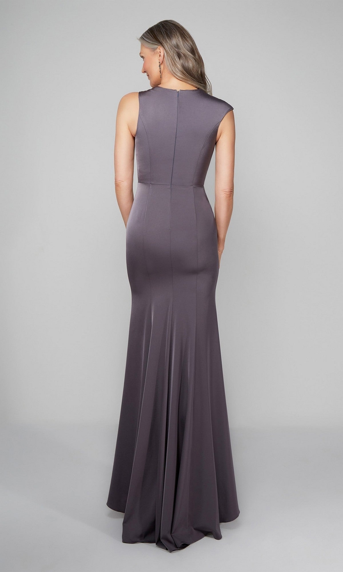 A woman faces away, wearing the Alyce 27598 long formal dress—a sleeveless, floor-length column gown in purple-gray with a slight bottom flare—set against a plain light background.