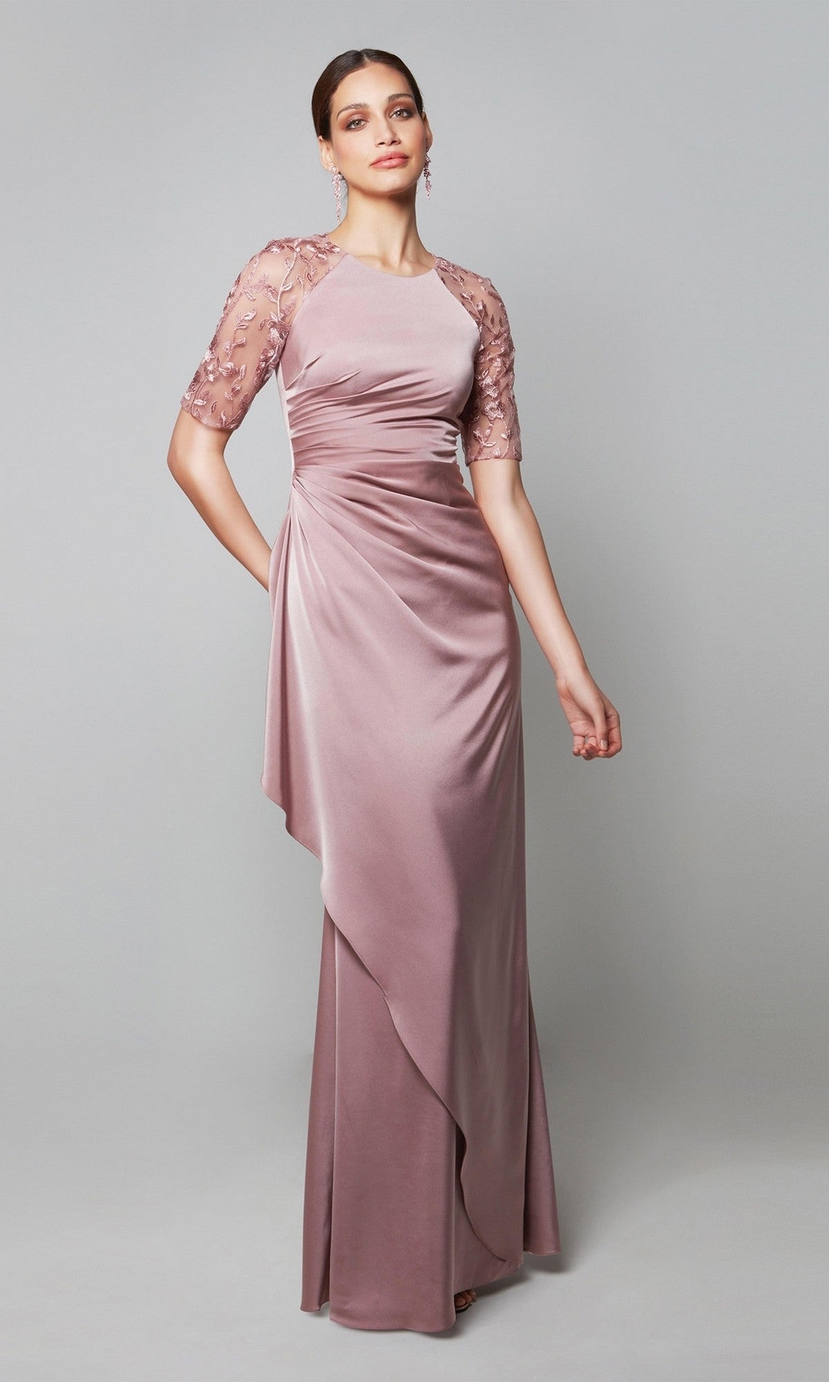 A woman models the Alyce 27601 long formal dress in mauve, featuring short sheer embroidered sleeves, against a plain light gray background—an ideal choice for an elegant mother-of-the-bride ensemble.
