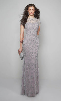 A woman in the Alyce 27607 long formal dress—a floor-length, beaded lavender evening gown with short sleeves—holds a silver clutch while standing against a plain light gray background.