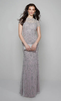 A woman stands against a plain background wearing the Alyce 27607—a floor-length, light lavender beaded long formal dress—and holds a matching clutch.