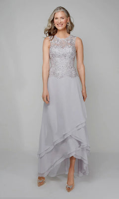 A woman in the Alyce 27608 long formal dress—sleeveless, light gray chiffon with a beaded lace bodice and layered asymmetrical skirt—stands against a plain background. An elegant choice for mothers of the bride.