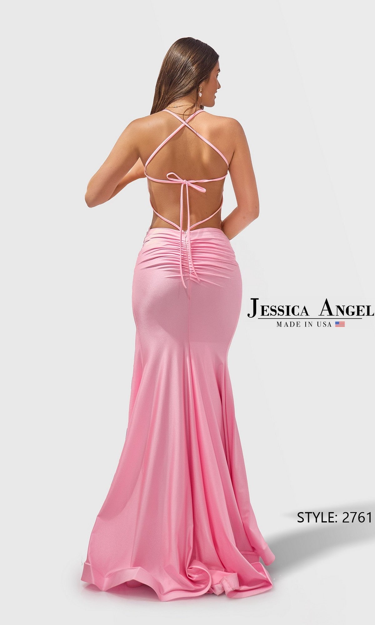 A woman poses with her back to the camera in the Long Prom Dress: Jessica Angel 2761—a floor-length, backless pink stretch-jersey gown with crisscross straps. 