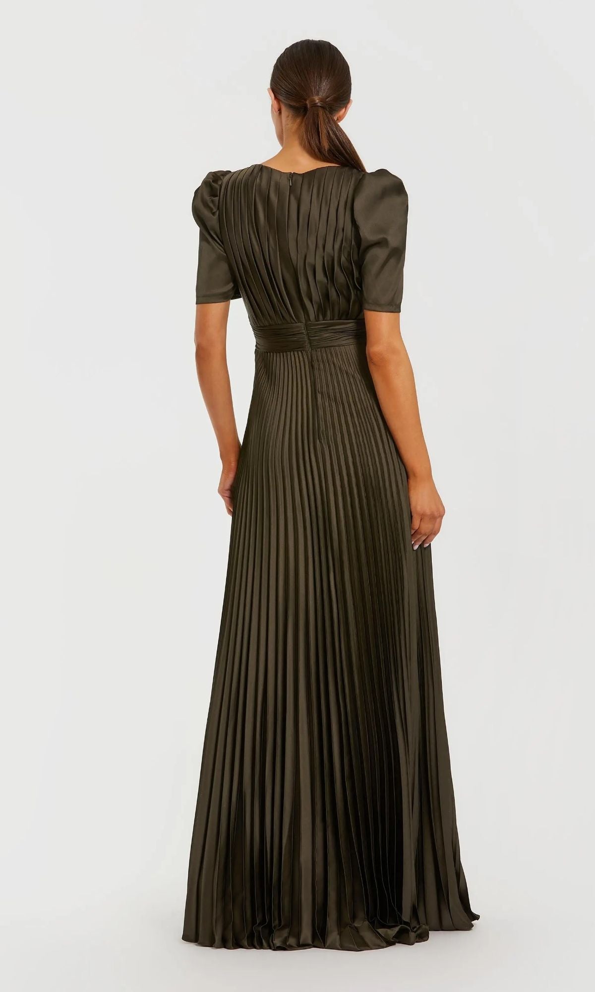A woman faces away, wearing the Mac Duggal 27616 long formal dress—an olive green, floor-length gown with short sleeves, pleats, and a fitted waist.