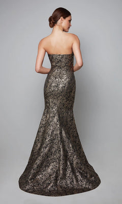 A woman faces away, wearing the Alyce 27621 long formal dress—a strapless jacquard gown with a metallic mermaid silhouette and textured pattern. Her hair is in a low bun, complementing the evening look against a plain gray background.