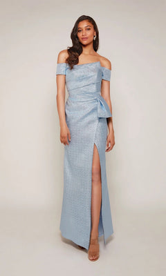 A woman models the Alyce 27639 long formal dress—an off-the-shoulder, light blue gown with a side slit and bow detail—against a plain background.