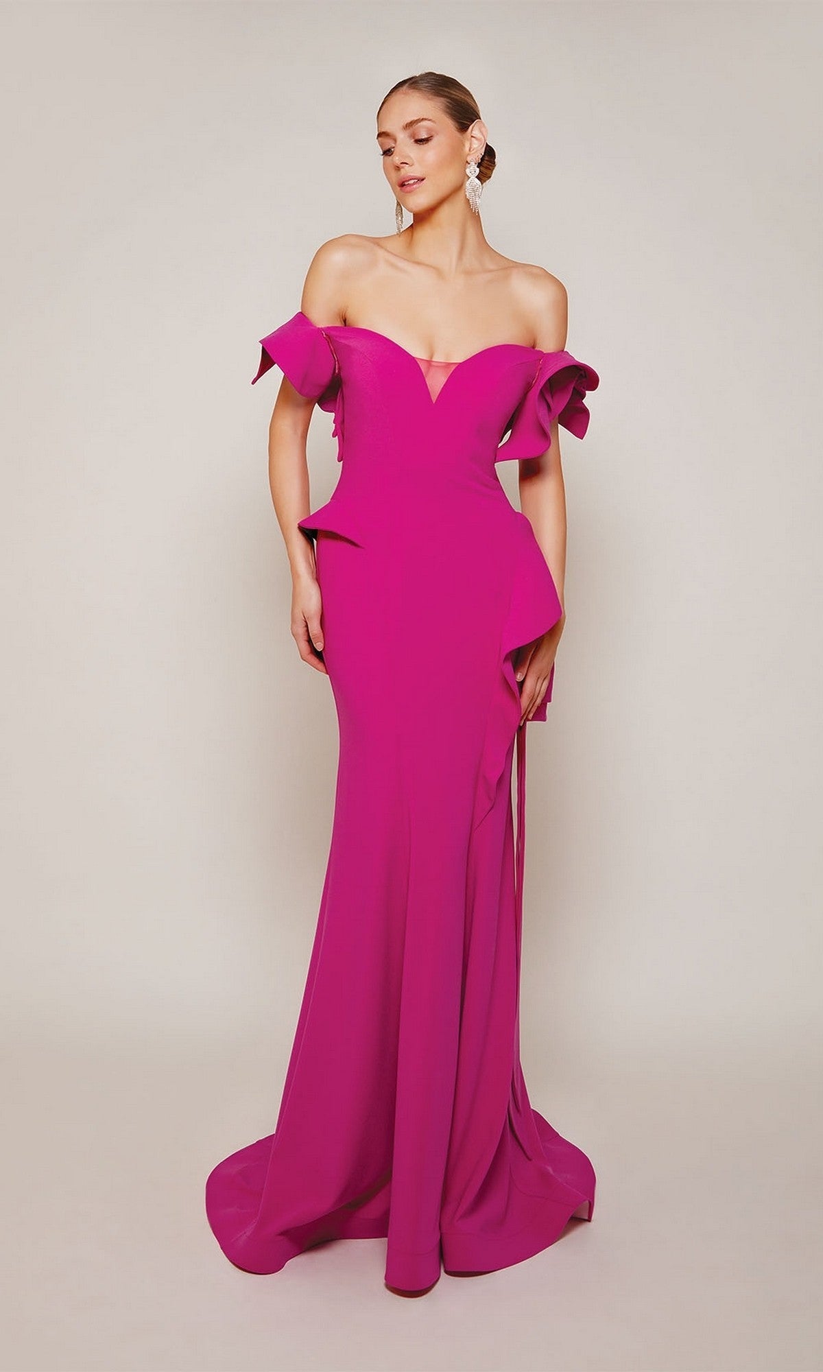A woman stands against a plain light background wearing the Alyce 27643 long formal dress in magenta, featuring ruffled sleeves and a fitted off-the-shoulder gown silhouette.