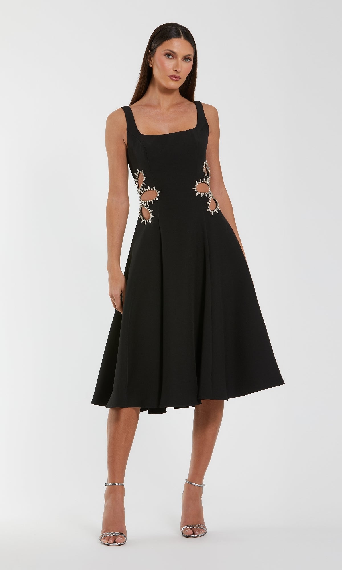 Woman wearing a black dress with floral embellishments on a white background