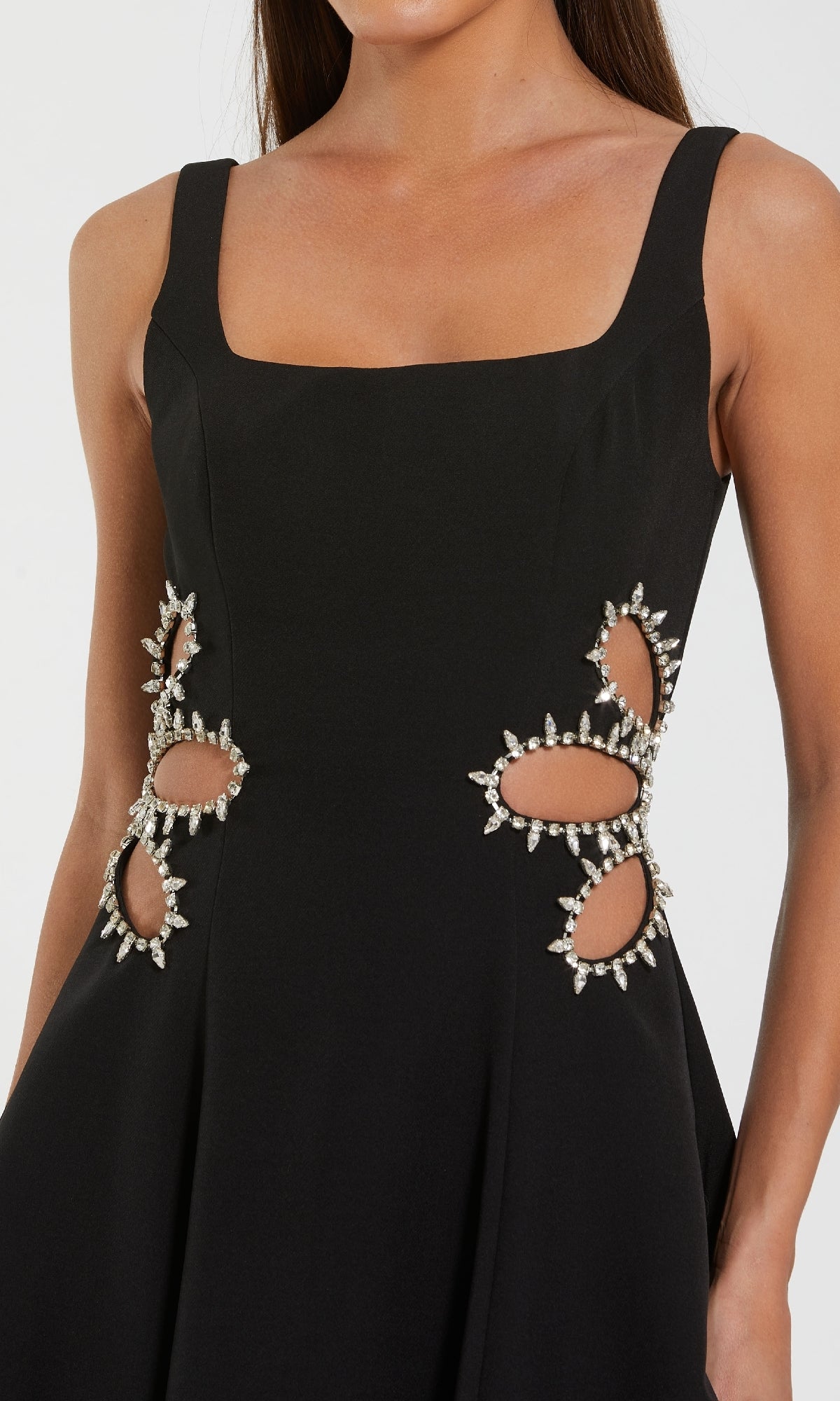 Black dress with cut-out designs and embellishments on a white background