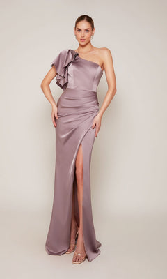 A woman in the Alyce 27656 long formal dress in smoke, featuring a one-shoulder satin design with a ruffled sleeve, sheath faux wrap skirt, and thigh-high slit, stands against a plain background wearing strappy heels.
