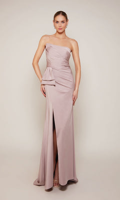 A woman poses against a plain light background in the Alyce 27658 long formal dress—a strapless light mauve stretch crepe gown with a side bow and front slit, perfect for a mother of the bride.