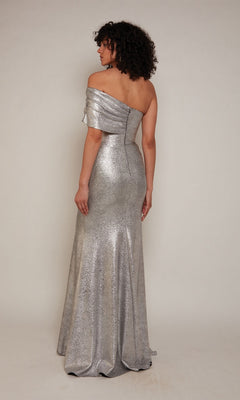 A woman with curly hair models the Alyce 27663 long formal dress—a silver, off-the-shoulder, floor-length gown with a metallic jacquard finish—photographed from the back against a neutral background.