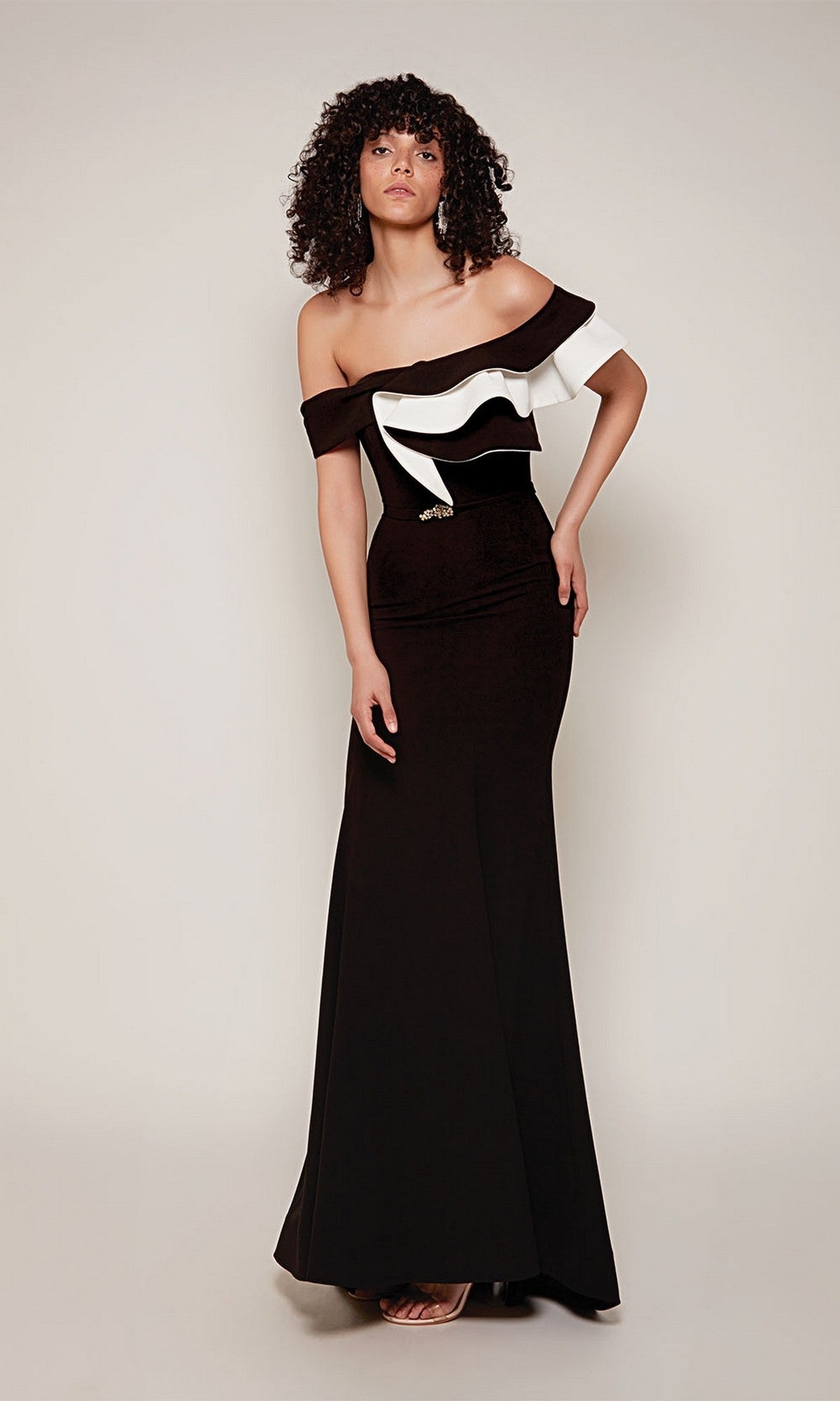 A woman models the Alyce 27672 long formal dress, a fitted sheath silhouette with off-the-shoulder two-tone ruffle detail, standing against a plain light background.