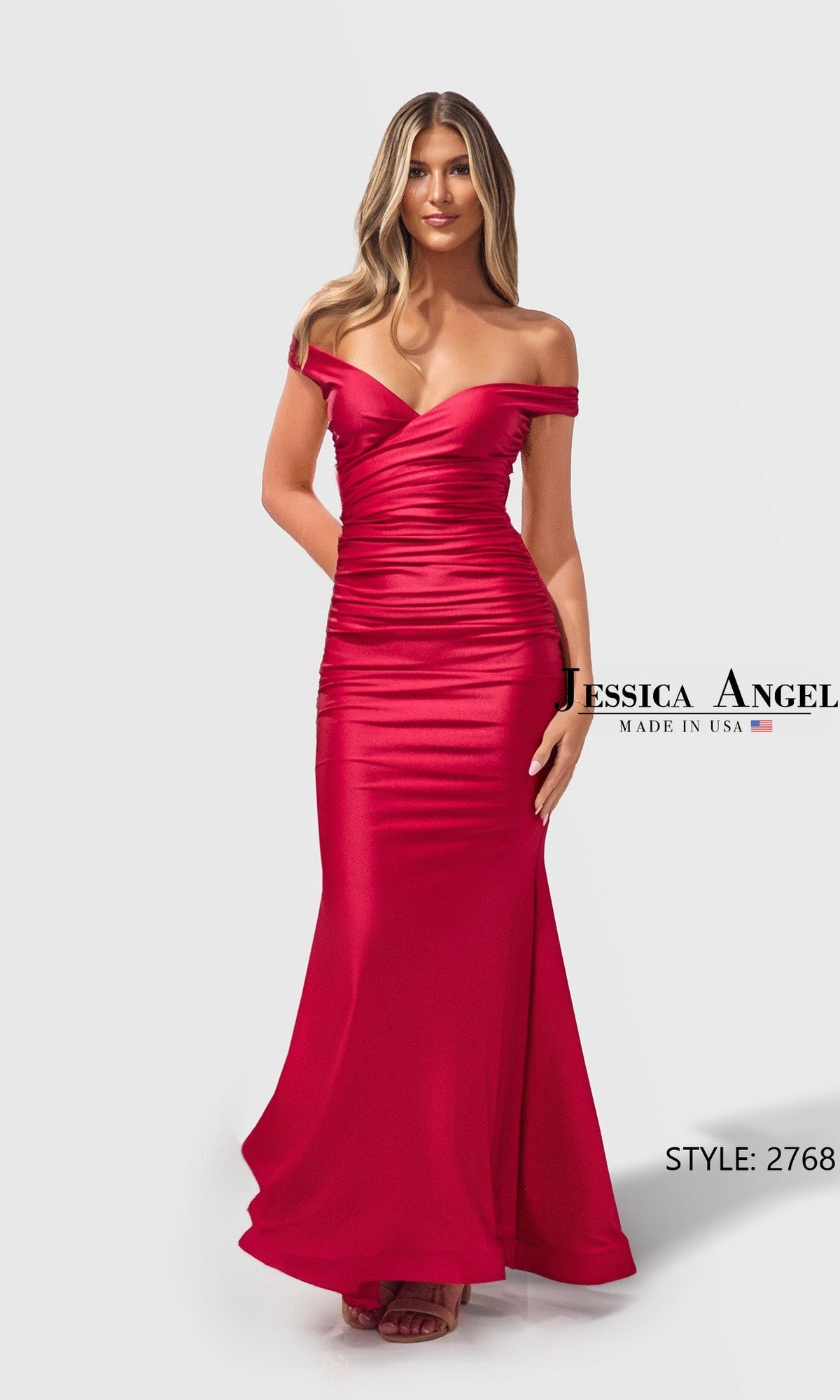 A woman wearing the Jessica Angel 2768 long prom dress in red—an off-the-shoulder, floor-length fitted gown with ruched details. Made in the USA, this eye-catching jersey dress is perfect for making a statement.