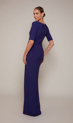 A woman poses in a studio, wearing the Alyce 27682 long formal dress—a fitted, floor-length purple gown with short sleeves and a v-neckline—glancing over her shoulder.
