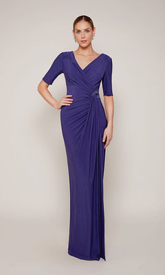 A woman stands against a plain background wearing the Alyce 27682, a floor-length purple formal dress with a jersey fabric, short sleeves, gathered waist, and v-neckline.