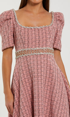 Woman wearing the Mac Duggal 27687 Midi Wedding Guest Dress in pink, with puff sleeves, a square neckline adorned with crystal embellishments, and a rhinestone-beaded belt at the waist.