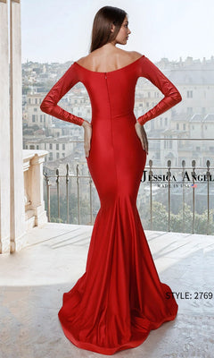 A woman in a Jessica Angel 2769 long prom dress with off-the-shoulder satin and long sleeves stands on a balcony, facing away from the camera and overlooking the city.