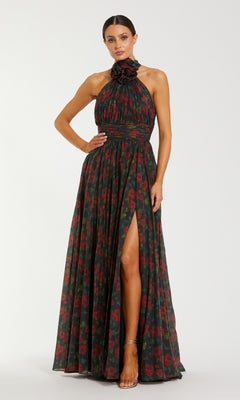 Woman wearing a floral halter neck gown with a high slit on a white background