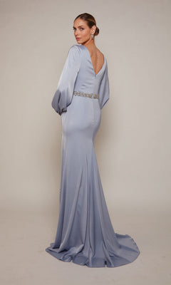 Alyce 27696: Woman in a long formal light blue dress with deep V-back, long sleeves, and beaded waistband—an elegant choice for mothers of the bride. Plain backdrop highlights its sophisticated style.