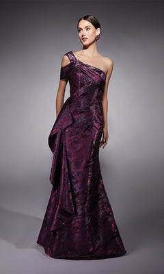 Woman wearing an Alyce 27701 long formal dress in fuchsia, featuring a floor-length, one-shoulder jacquard design with a textured metallic finish, standing against a plain gray background.