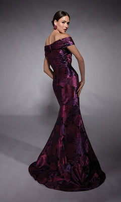 A woman poses in the Alyce 27702 long formal dress, an off-the-shoulder, floor-length jacquard gown with a purple and black floral pattern and fitted silhouette—ideal for the modern mother of the bride—against a gray background.