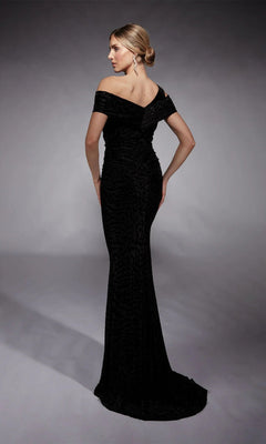 In a studio setting, a person faces away wearing the Long Formal Dress: Alyce 27709, which features an off-the-shoulder asymmetric neckline, fitted silhouette, and textured pattern.