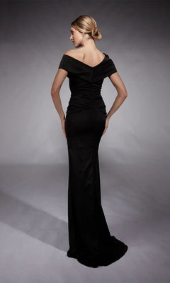 Woman poses with hands on hips in the Alyce 27710 long black formal dress, featuring off-the-shoulder sleeves, elegant ruching, and a dramatic train.