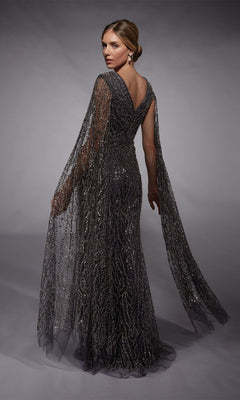 A woman models the floor-length Alyce 27725 long formal dress, a fitted sheath with sparkling patterns and sheer draped cape sleeves, posed against a gray background.