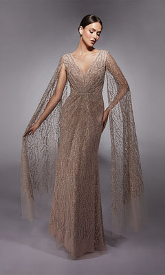 A woman wearing the Alyce 27725 Long Formal Dress, a floor-length shimmering sequin gown with sheer flowing cape sleeves, stands gracefully against a neutral background.