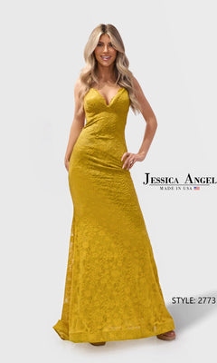 A woman wears the Long Prom Dress: Jessica Angel 2773 in mustard, featuring a floor-length, fitted silhouette with a deep V-neckline and open-back design.
