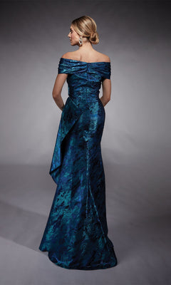 A woman stands with her back to the camera in the Alyce 27737 long formal dress, featuring an off-the-shoulder blue and green jacquard design—a refined mother-of-the-bride choice against a gray backdrop.