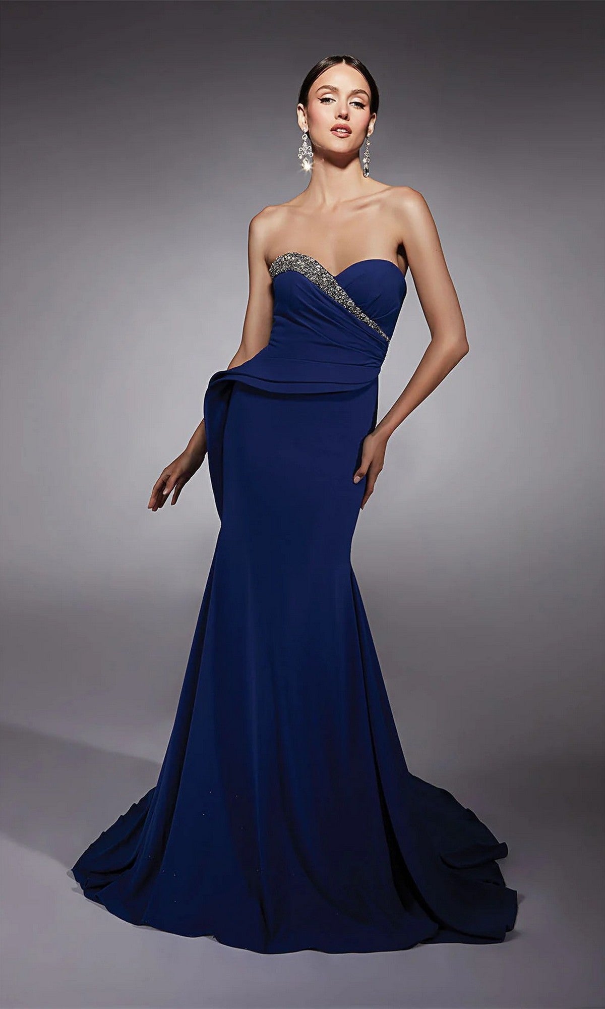 A woman models the Alyce 27739 long formal dress—strapless, dark blue, floor-length—with a fitted silhouette, beaded details, and a graceful sweetheart neckline.