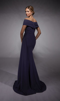 A woman poses with hands on hips against a plain backdrop, modeling the Alyce 27745 Long Formal Dress—an elegant off-the-shoulder, floor-length gown perfect for prom night.