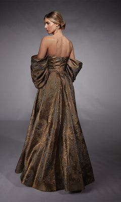 Wearing the Alyce 27760 long formal dress with detachable puff sleeves, a woman faces away, her hair in a low bun, highlighting the elegant jacquard metallic fabric against a neutral backdrop.