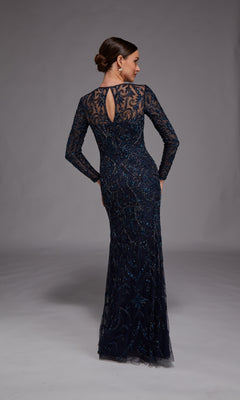A woman models the Alyce 27778, a dark blue long formal dress with intricate beading—an elegant choice for the mother of the bride—standing with her back to the camera against a plain grey background.