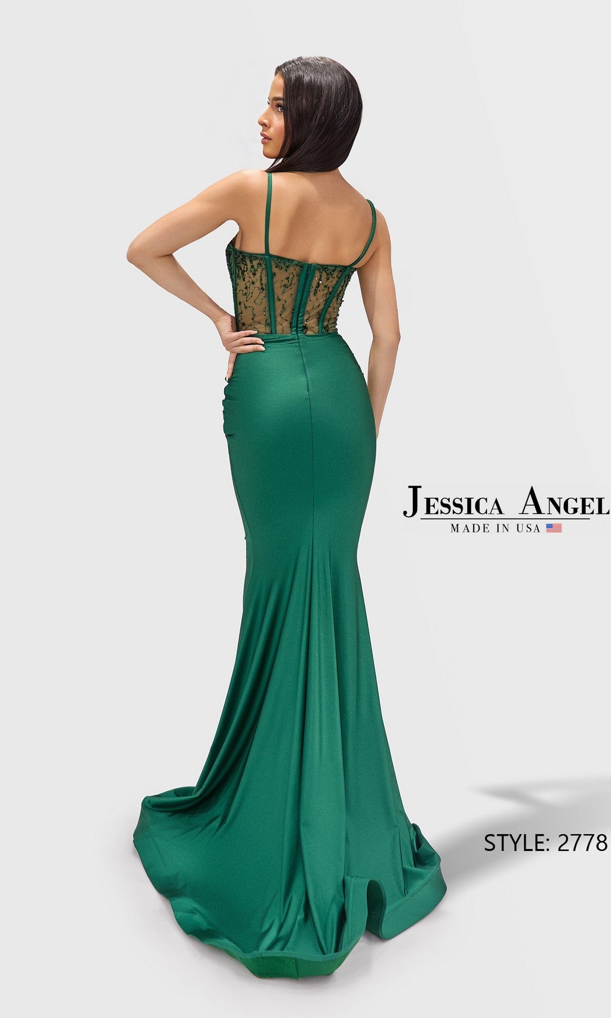A woman models the Long Prom Dress: Jessica Angel 2778—a fitted green gown with a corset bodice, lace-up sheer back, and spaghetti straps—standing against a plain white background.