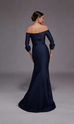 A woman in the Alyce 27782 Long Formal Dress stands facing away with her hair in a low bun against a neutral gray background.
