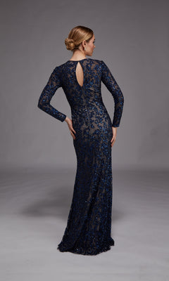 A woman stands with her back to the camera, one hand on her hip, in a floor-length navy blue long-sleeve sequined gown (Long Formal Dress: Alyce 27788) against a plain gray background.