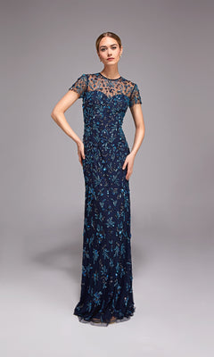 A woman models the Alyce 27789, a long formal navy blue gown with short sleeves and detailed blue floral embellishments, set against a plain gray background.