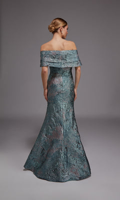 A woman faces away from the camera wearing the Alyce 27794, a metallic jacquard long formal dress featuring an off-the-shoulder neckline and flared hem. Her hair is styled in a sleek low bun, completing her elegant look for any formal occasion.