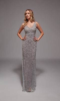 A woman poses in a studio wearing the Alyce 27799—a sleeveless, floor-length silver beaded Long Formal Dress adorned with intricate patterns, ideal for formal occasions.