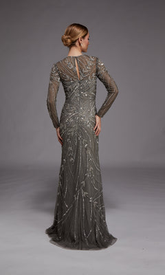 A woman faces away, wearing the Alyce 27801 long formal dress—a fitted grey evening gown with sheer sleeves and intricate silver bead embellishments—set against a plain grey background.