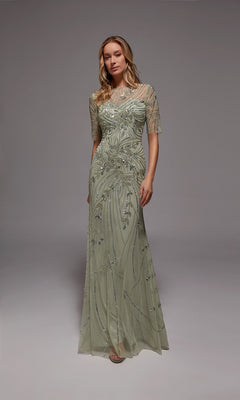 A woman stands against a plain gray background in the Alyce 27809 long formal dress, mint/silver with beaded accents and sheer short sleeves—ideal for formal events or as an elegant mother-of-the-bride gown.