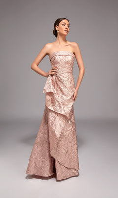 A woman stands against a plain gray background wearing the Alyce 27818 Long Formal Dress, a floor-length strapless jacquard blush pink gown with ruffled details—ideal for special occasions.