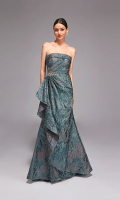 A woman wears the Long Formal Dress: Alyce 27818, a strapless floor-length metallic teal jacquard gown with a textured pattern and draped waist—ideal for special occasions—standing against a plain gray background.